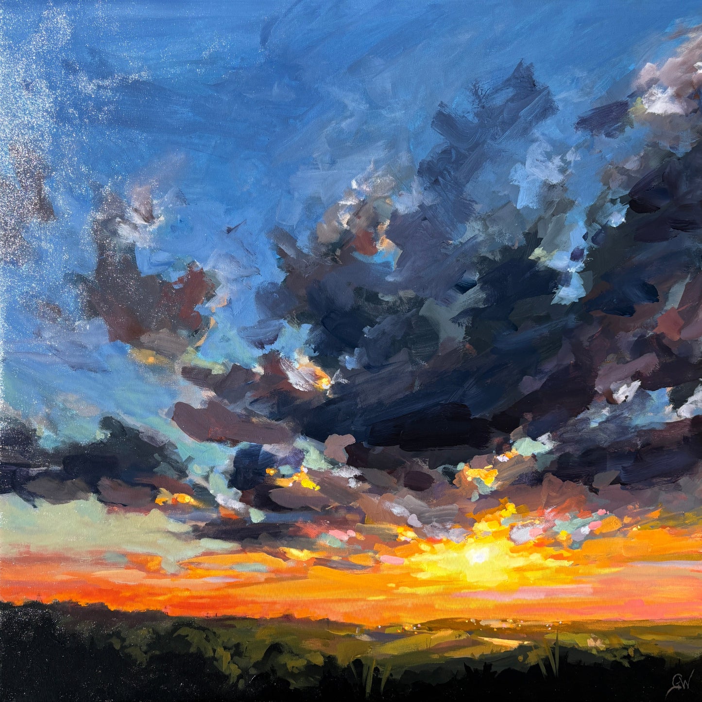 An oil painting of a dramatic sunset landscape, featuring dark storm clouds, a bright yellow and orange sunburst, and a blue sky, housed in a light wood frame and mounted on a gray stone wall.